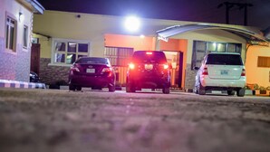 A driveway with three cars parked in front of a house at night. - Power Mike Guest House (Abuja)