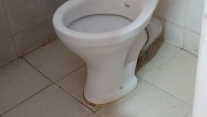 Un inodoro en un baño con piso de baldosas.