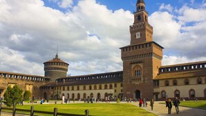 Un edificio histórico con un patio central, que destaca por una torre principal y otra torre circular.
