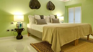 Ein Schlafzimmer mit einem Bett, zwei Wandlampen, einem Nachttisch mit Lampe, einem kleinen Dekorationsgegenstand und einem gemusterten Teppich.