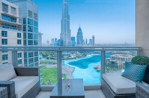 Un balcón con vista a un horizonte urbano, incluyendo una torre destacada, y un cuerpo de agua con un puente.