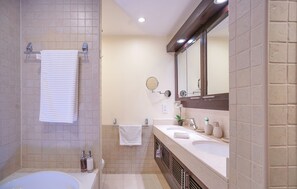 Un baño moderno con bañera, lavabo, espejo y toallero.
