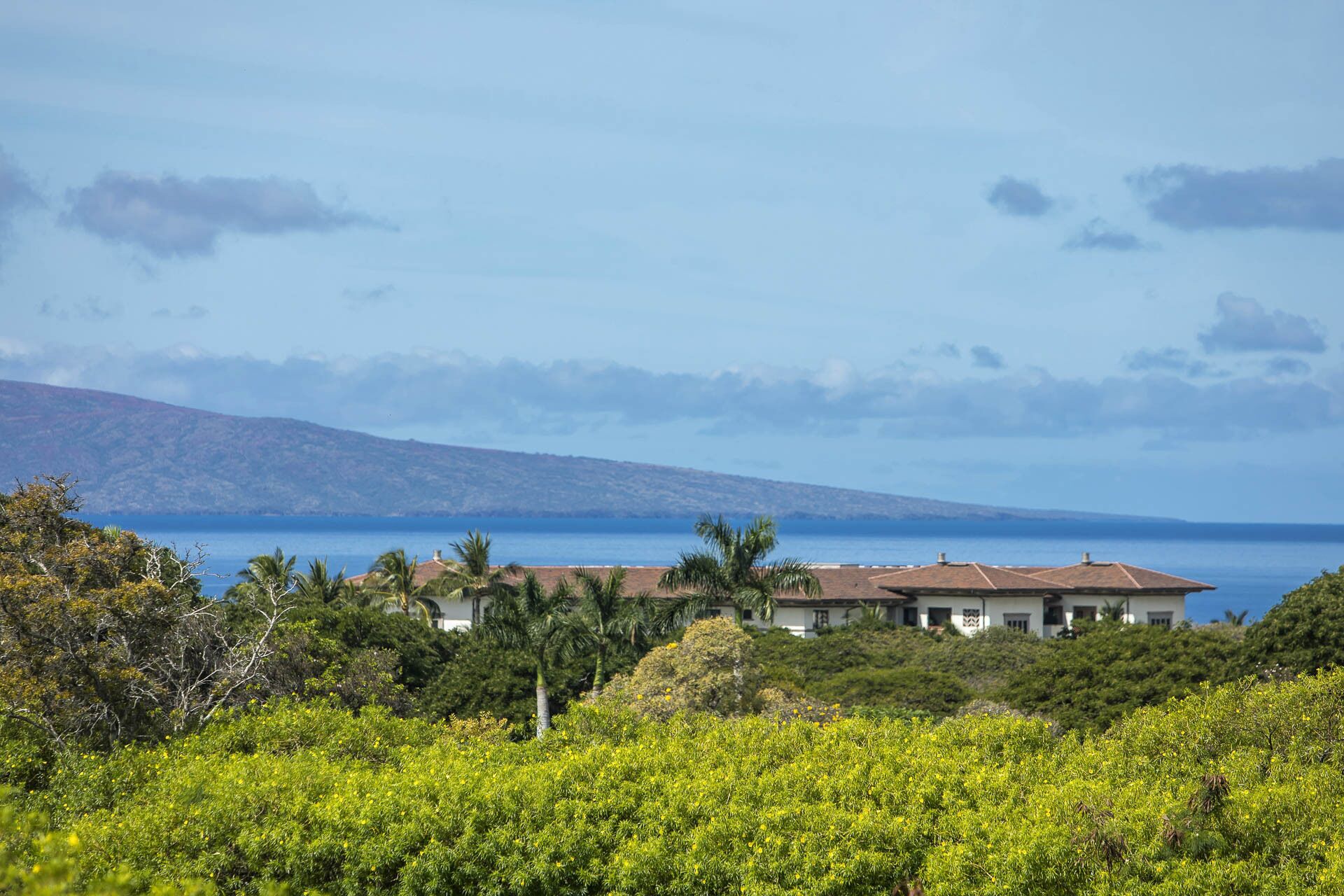 Ein Küstenanwesen mit Blick auf das Meer und einem Berg im Hintergrund.