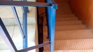 Uma escadaria com corrimãos azuis e degraus brancos.