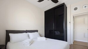Ein Hotelzimmer mit Bett, Kleiderschrank und Deckenventilator.