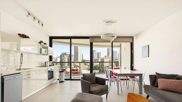 A modern apartment with a kitchen, dining area, and living room.