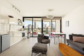 A modern apartment with a kitchen, dining area, and living room.