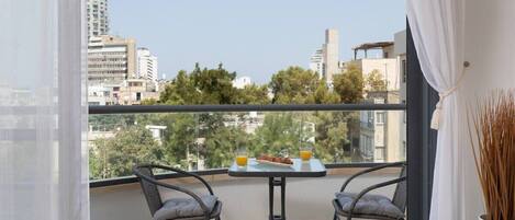 A balcony with two chairs, a small table, and a potted plant.