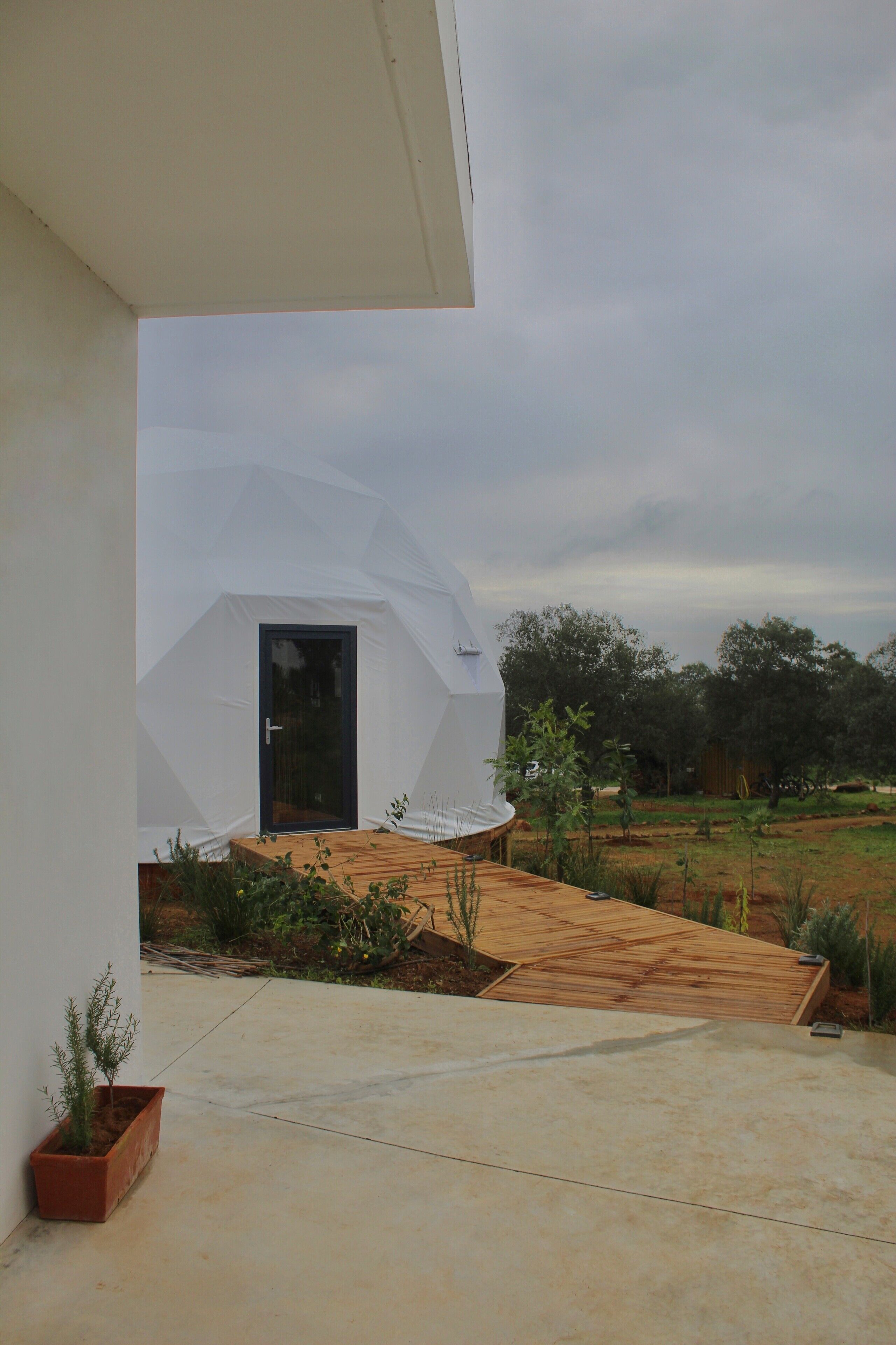 A modern house with a white exterior, a wooden deck, and a door.