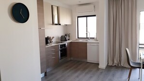 Een moderne keuken met een inbouwoven, een vaatwasser en een groot raam.