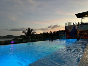 A swimming pool with a view of the sunset and mountains in the background. - Outpost Hostel - Coron - Adults Only (Coron)
