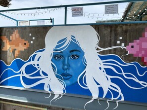A mural with a woman's face and flowing hair on a wall. - Outpost Hostel - Coron - Adults Only (Coron)
