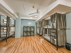 A dormitory room with bunk beds, a ceiling fan, and a wooden floor. - Outpost Hostel - Coron - Adults Only (Coron)