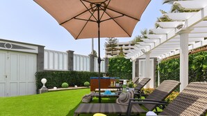 A backyard with a pergola, outdoor furniture, and a small table with a drink. - Jacuzzi Garden Holiday Home (Playa del Inglés)