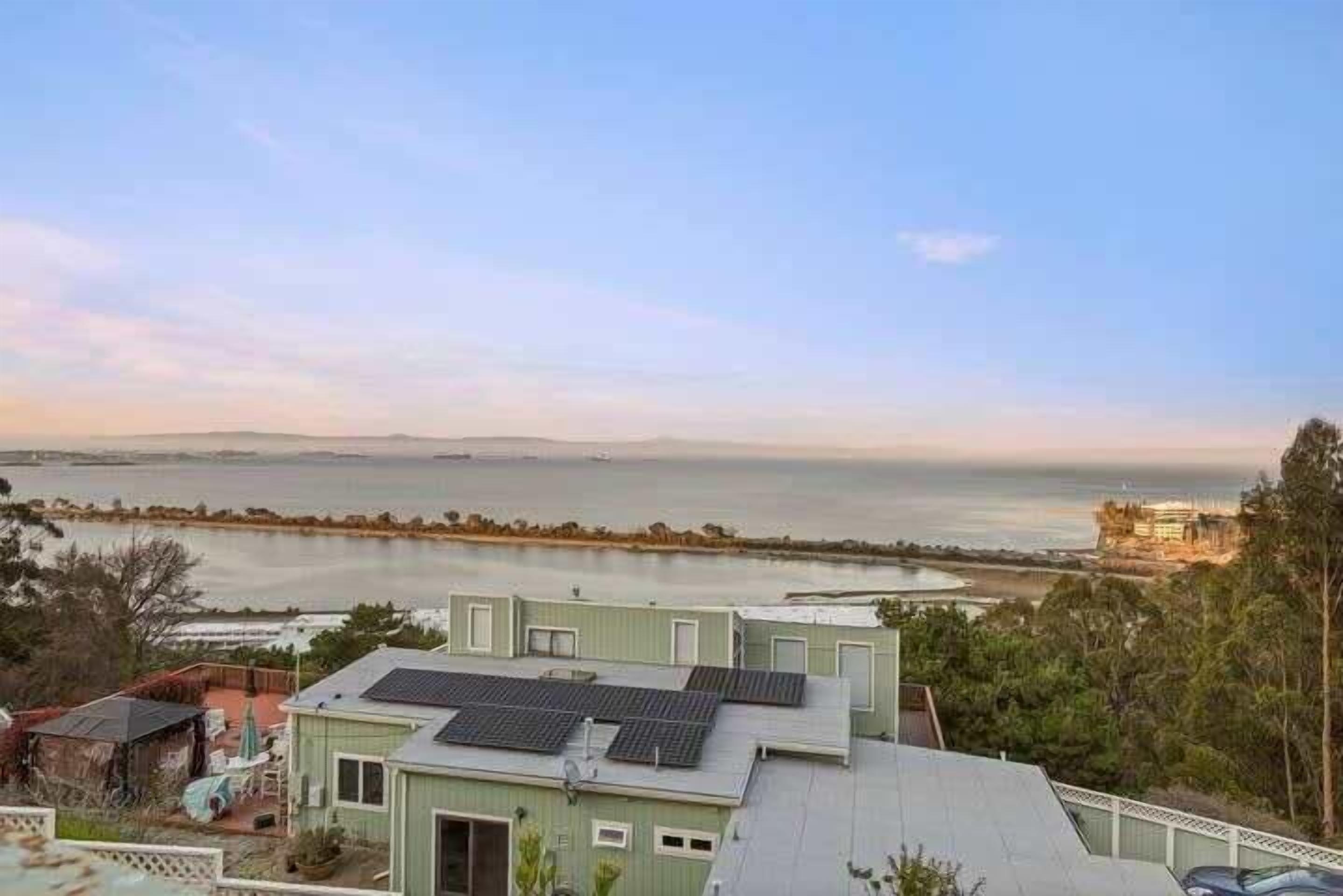 A coastal property with a view of the sea and distant mountains.