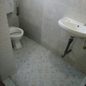 Un bagno con il water, un lavandino e piastrelle a pavimento decorate.