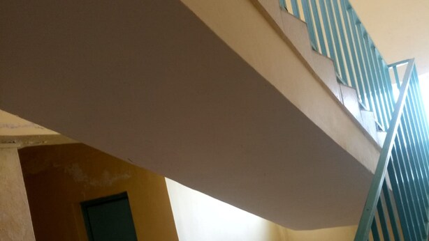 A staircase with a green handrail leading to an upper floor. - Kilimanjaro Guest House (Nakuru)