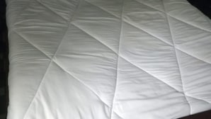 A bed with a white quilted bedspread and two pillows. - Kilimanjaro Guest House (Nakuru)