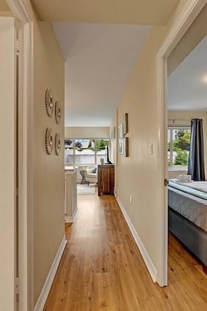 Stylish hallway leads to a cozy bedroom with a window offering a view of the outdoors.