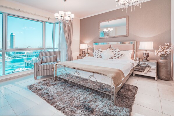 A modern bedroom with a large bed, a view of a cityscape, and a city view through large windows. - Elite Royal Apartment - Burj Khalifa & Fountain view - Crystal (Dubai)