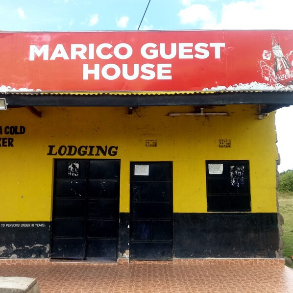 A building with a red and yellow facade, labeled "Marico Guest House" and "Lodging."