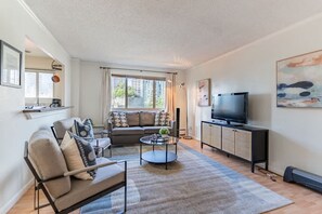 A modern living room with a sofa, coffee table, and TV.