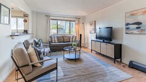 Een moderne woonkamer met een bank, salontafel en televisie.