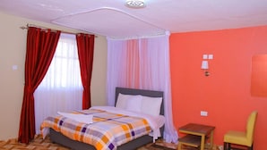 Une chambre à coucher avec un lit, une petite table, une chaise et une table de chevet.