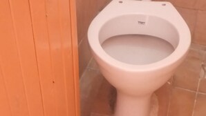 A toilet with a white seat and a label that reads "Vibgyor." - Njiwa Guest House (Nakuru)