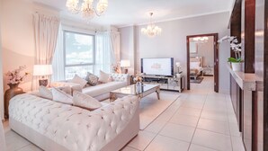 Ein modernes Wohnzimmer mit einer großen Couch, einem Fernseher und einem Essbereich.