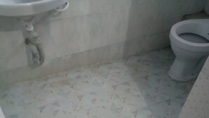 A bathroom with a sink, toilet, and patterned floor tiles. - Qwetu Guest House (Nakuru)