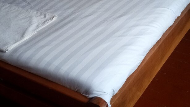Una cama con una colcha y almohadas a rayas.