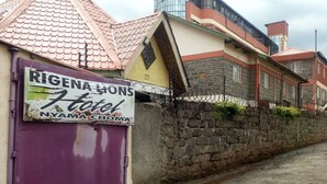 Un letrero de hotel con el nombre "RIGENA LIONS Hotel" y la ubicación "NYAMA CHOMA".