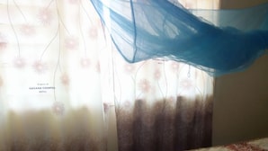A bedroom with a bed, curtains, and a mosquito net. - Sagana Country Hotel (Nyeri)