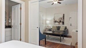 A bedroom with a bed, a chair, a coffee table, a sofa, and a ceiling fan. - Bright & Secluded Apartment with Pool Access (Charleston)