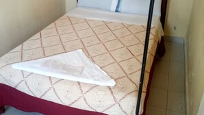 A single bed with a patterned bedspread and a white pillow. - Serena Hotel (Nakuru)