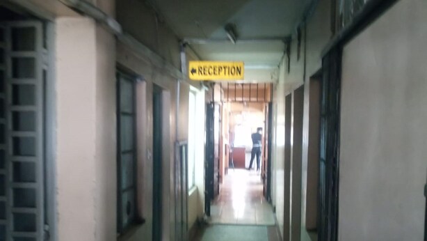 Un área de recepción con un cartel que indica el camino a la recepción.