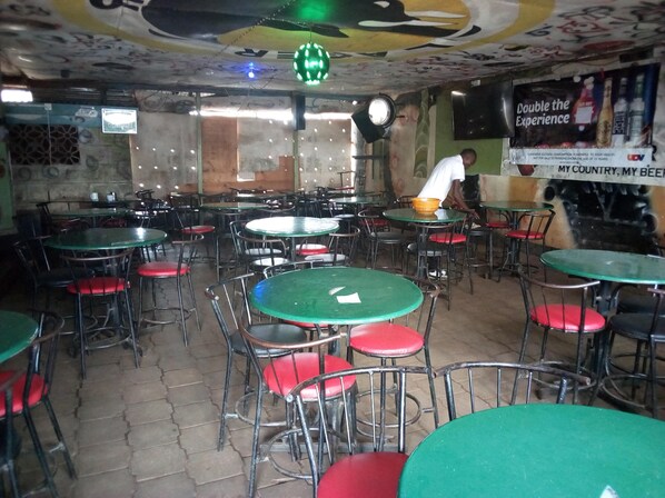 A restaurant with multiple round tables and chairs, some with red cushions. - Starwood Hotel Kagio (Kagio)