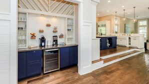 A modern kitchen with white cabinetry, a built-in island, and a wooden floor.