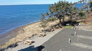 A parking area with picnic tables and a view of the ocean.