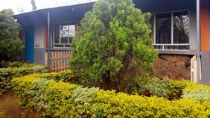 A two-story building with a stone facade and a wooden deck. - Wamagach Kahua- Ini Hotel (Nyeri)
