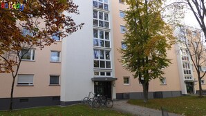 A multi-story building with a beige facade, large windows, and a central entrance. - Apartment Jungle Adventure (Günzburg)