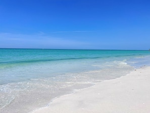 A beach with clear turquoise water and white sand.