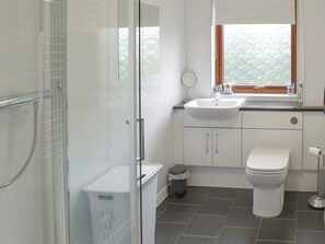 A modern bathroom with a glass shower enclosure, a white sink, a toilet, and a window with a view of water. - 3 bedroom accommodation in Tain (Tain)