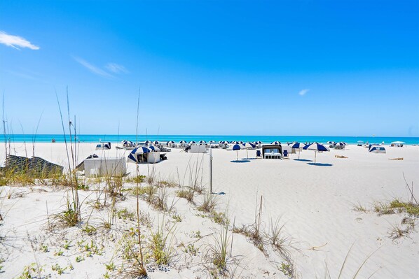 Relax on the beach with comfortable lounge chairs and umbrellas.
