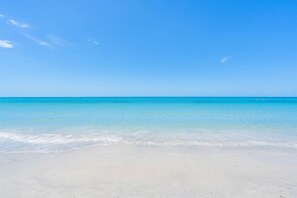 Ein Strand mit klarem, blauem Wasser und einem Sandstrand.