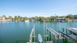 A marina with docked boats, a clear sky, and buildings in the background. - Cozy Waterfront Condo | Patio & Beach Access (St. Pete Beach)