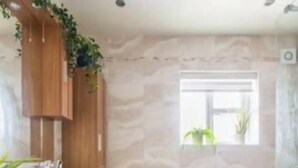 A modern bathroom with a wooden vanity, a toilet, and a shower area.