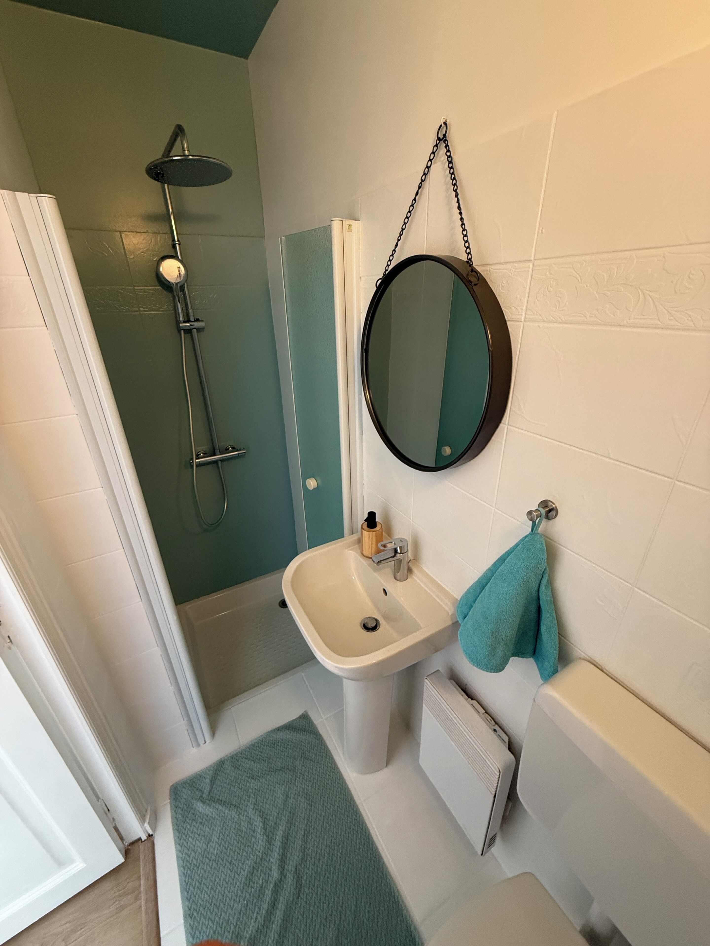 A bathroom with a shower, sink, and toilet.