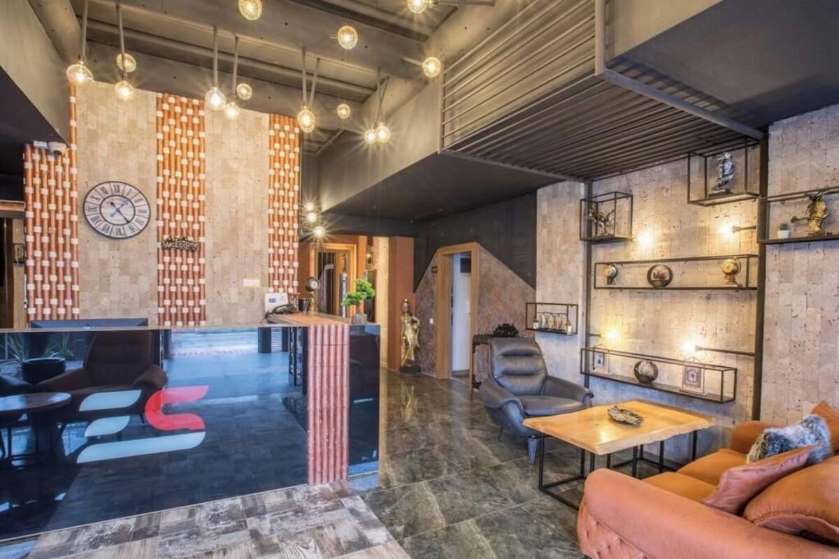 A modern lobby with a reception desk, seating area, and decorative wall elements.